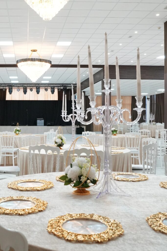Private event setup with crystal candelabra, gold charger plates and performance stage view at AWA Zug event venue