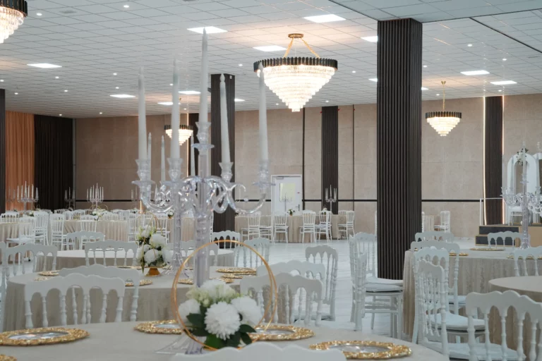 Fully decorated wedding banquet hall with multiple crystal chandeliers, candelabras and white floral centerpieces at AWA Zug event venue Switzerland